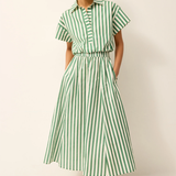 Woman wearing a green and white striped skirt on a plain background