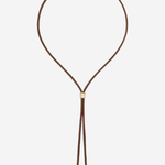 A brown leather cord necklace with a small gold-toned square charm and dangling cord ends, shown on a plain light gray background.