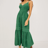 Woman wearing a green dress with intricate patterns on a white background