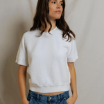 woman in white short sleeve top and denim on draped background 