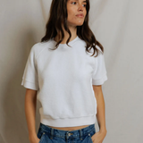 woman in white short sleeve top and denim on draped background 