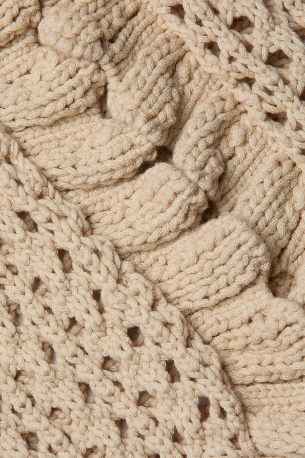 Close-up of a beige knitted fabric with a textured pattern
