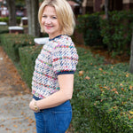 Tweed top with a structured silhouette in neutral tones.