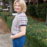 Tweed top with a structured silhouette in neutral tones.
