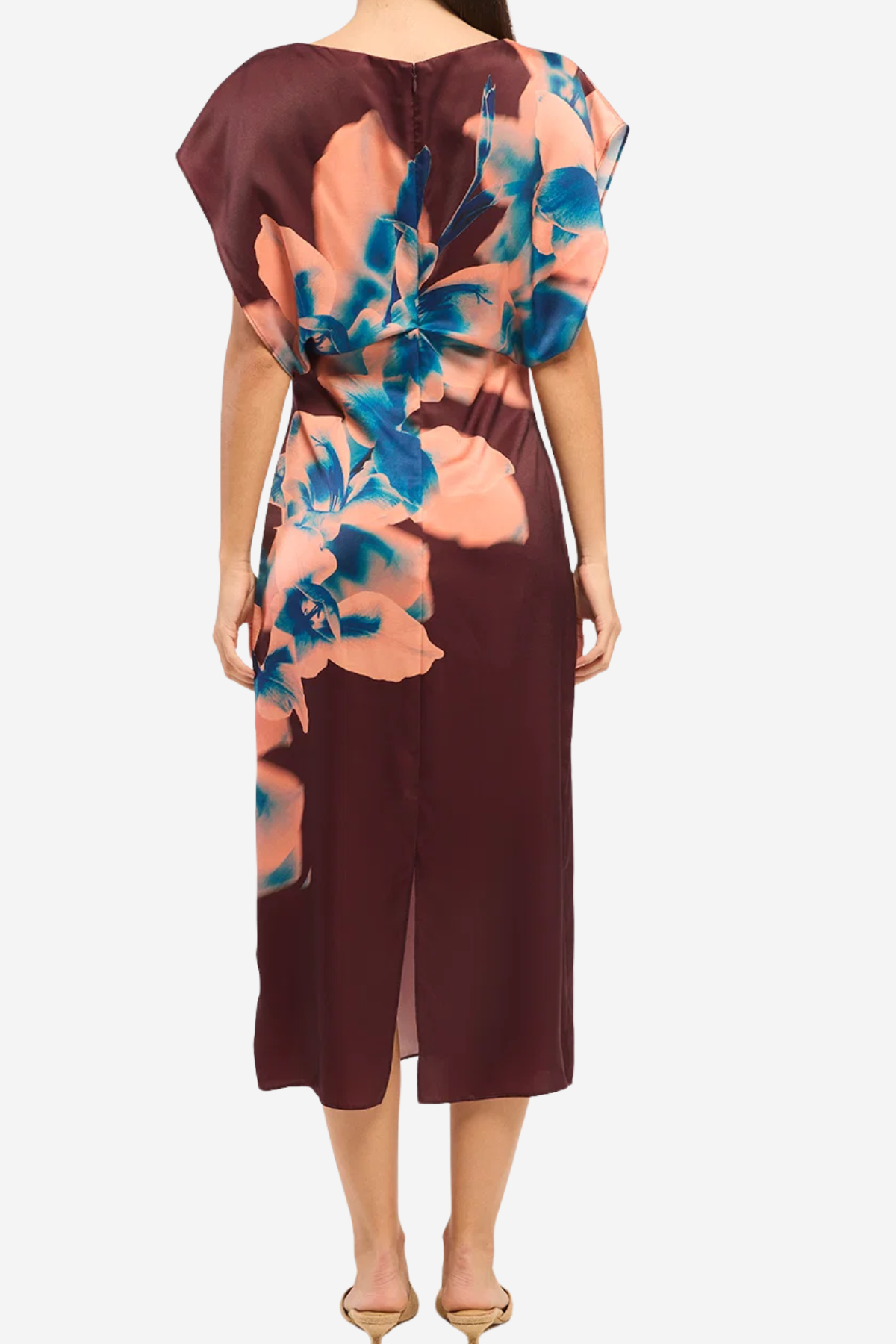 A woman modeling a midi dress from the back, featuring a deep burgundy base with a large peach and blue floral print on the upper back and shoulder area.