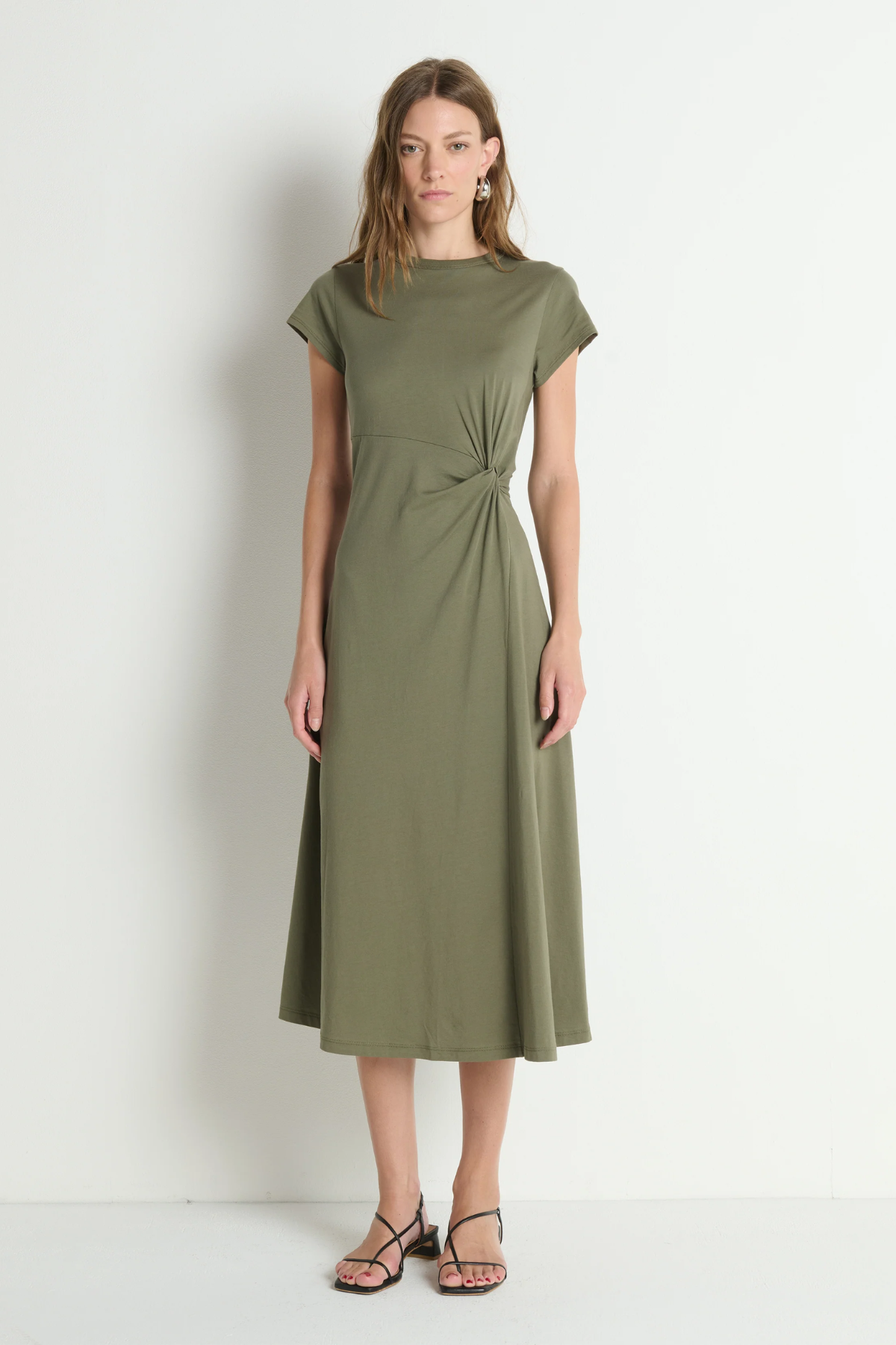 Woman wearing a green dress against a white background