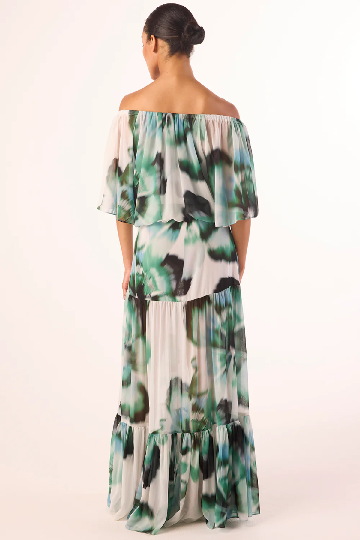 Woman wearing a floral off-shoulder dress on a white background