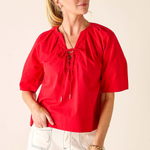 Woman wearing a red blouse with a beige background