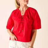 Woman wearing a red blouse with a beige background