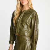 Woman wearing a green leather jacket and skirt on a white background