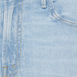 Close-up of light blue denim fabric with stitching details