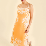 Woman wearing a yellow dress with white floral patterns on a beige background