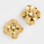 A pair of gold flower-shaped earrings with a clear rhinestone center, displayed on a clean white background.