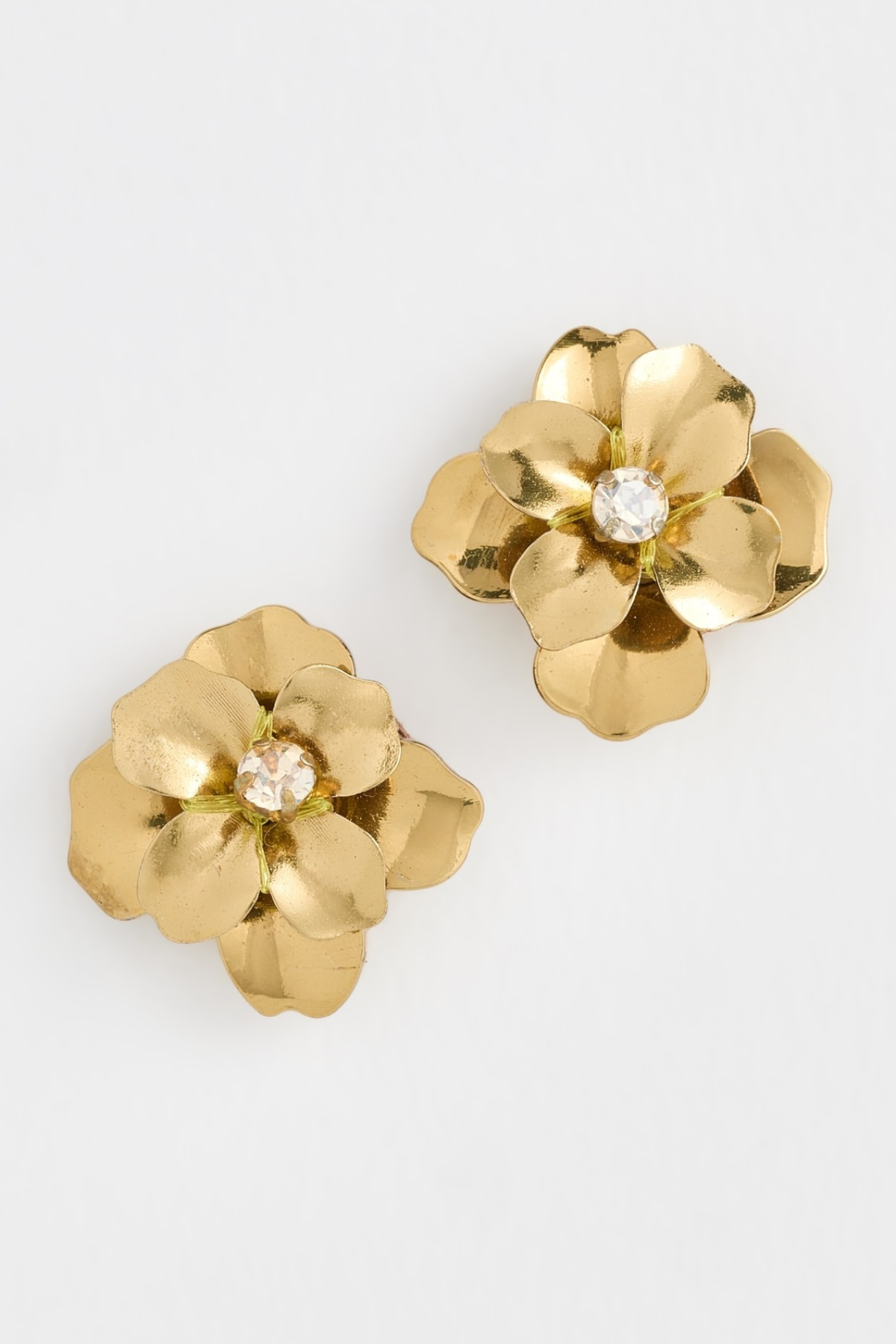 A pair of gold flower-shaped earrings with a clear rhinestone center, displayed on a clean white background.