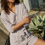 Woman in a striped outfit standing outdoors with cacti in the background
