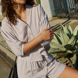 Woman in a striped outfit standing outdoors with cacti in the background