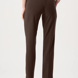 Model wearing slim-fit tailored pants with a streamlined ankle-length silhouette in a classic solid color.