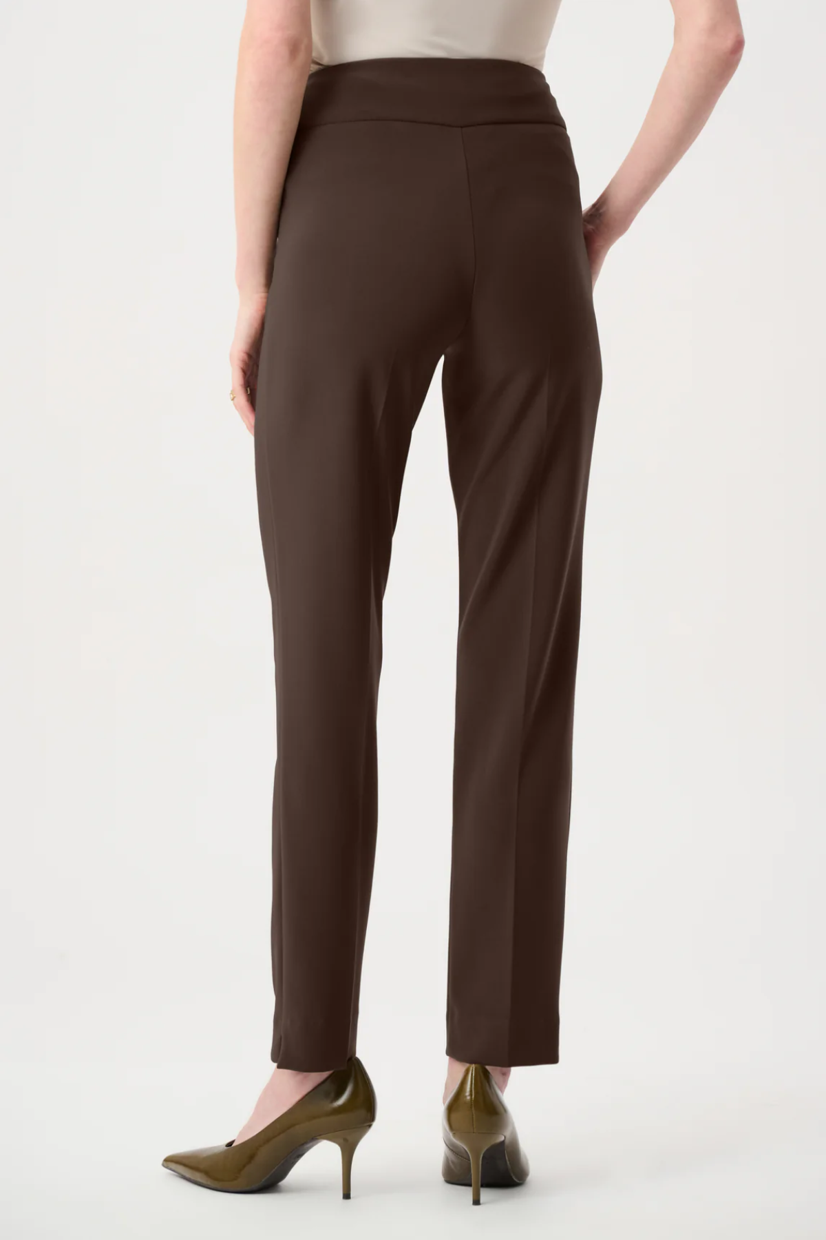 Model wearing slim-fit tailored pants with a streamlined ankle-length silhouette in a classic solid color.