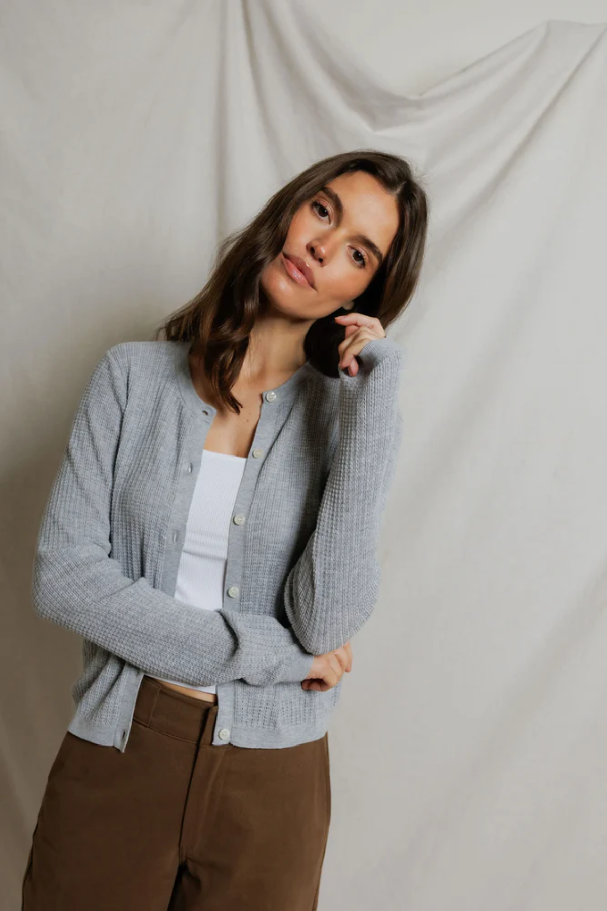 woman in grey cardigan on draped background 