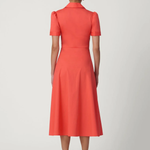 Woman wearing a coral dress on a white background