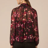 Woman wearing a floral blouse with a beige background