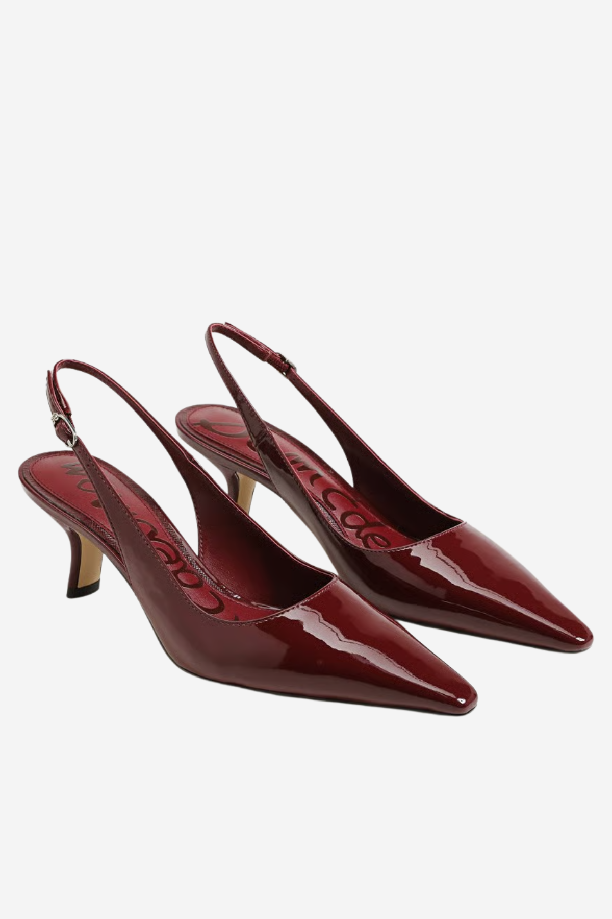 A pair of glossy burgundy patent leather slingback kitten heels with pointed toes, displayed on a light gray background.