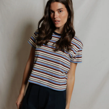 Woman wearing a striped shirt and black shorts against a plain background