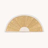 Semicircular woven mat with gold pattern on a white background