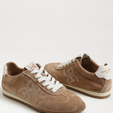 Pair of brown sneakers with white laces on a white background