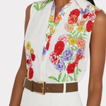 Woman wearing a sleeveless blouse with colorful floral pattern on a white background
