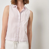 Woman wearing a sleeveless pink striped shirt against a plain background