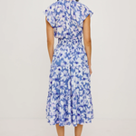 Woman wearing a blue floral dress on a light gray background