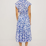 Woman wearing a blue floral dress on a light gray background