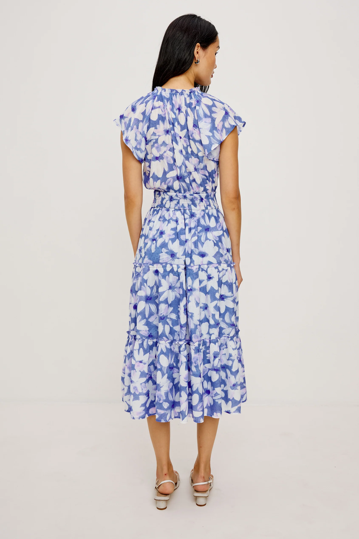 Woman wearing a blue floral dress on a light gray background