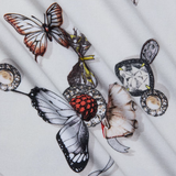 Close-up of fabric with tattoo-style butterfly and bird design on a white background