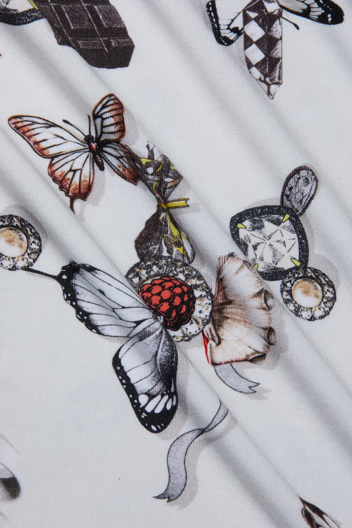 Close-up of fabric with tattoo-style butterfly and bird design on a white background