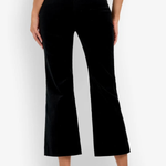 Black velvet cropped flare pants shown on a model from the back, paired with a white ribbed top and white heeled sandals against a white studio background.