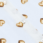 Gold heart-shaped earrings on a light blue background
