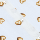 Gold heart-shaped earrings on a light blue background