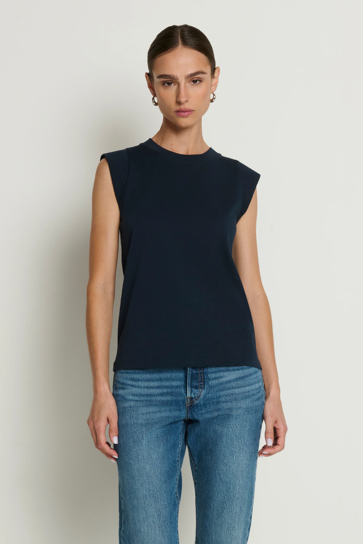 Model wearing a navy sleeveless muscle tank with a relaxed fit.