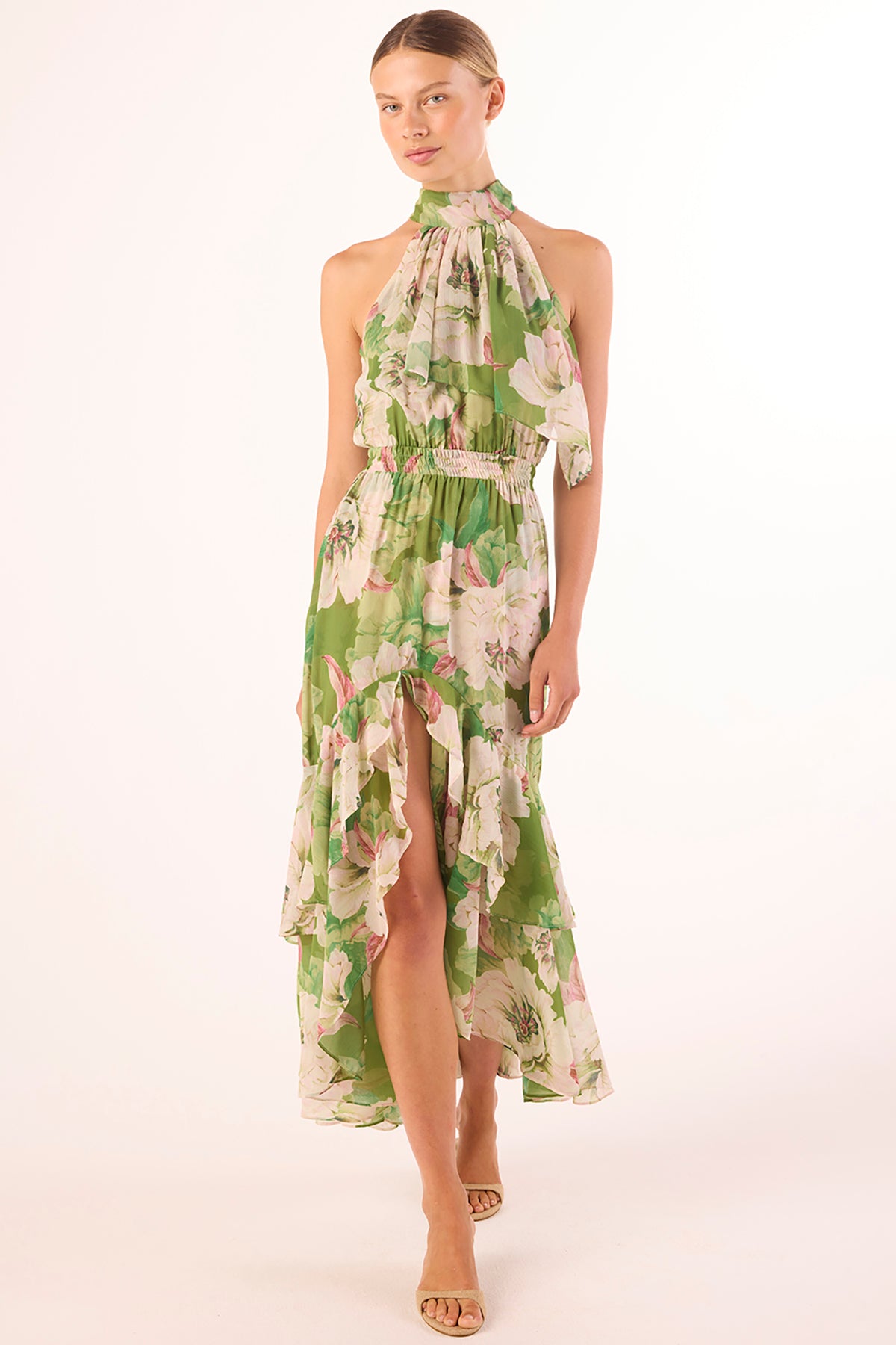Model wearing a green floral dress on a white background