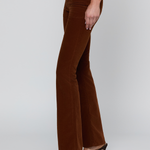 A model wearing brown corduroy flare pants and dark brown heeled sandals, shown from the waist down against a light gray studio background.