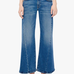 A model wearing a pair of medium-wash blue denim flare jeans with a straight-to-wide leg, paired with beige pointed-toe heels against a plain white background.