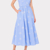 Woman wearing a blue dress with white floral patterns on a white background