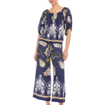 Woman wearing a navy blue floral jumpsuit on a white background