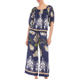 Woman wearing a navy blue floral jumpsuit on a white background