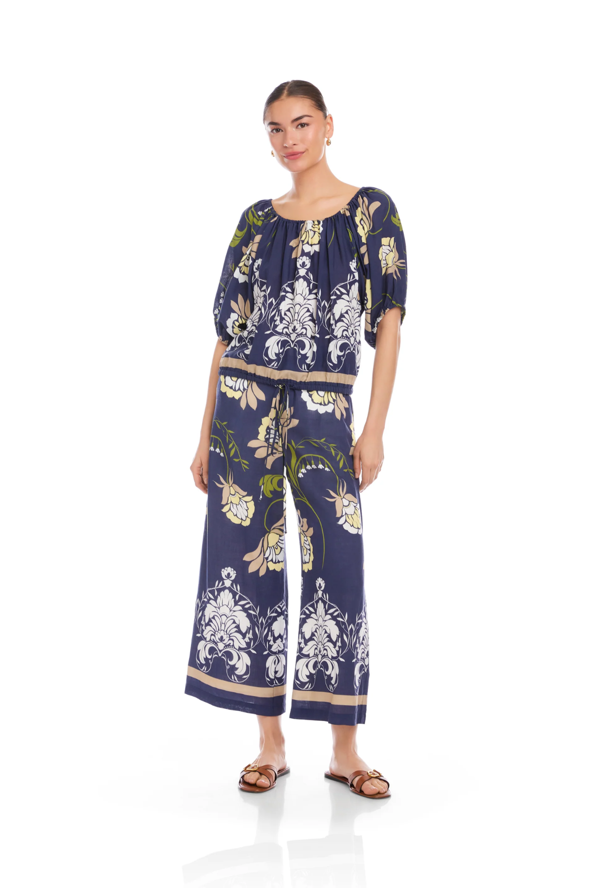Woman wearing a navy blue floral jumpsuit on a white background