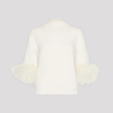 An off-white knit mock-neck sweater with three-quarter sleeves featuring fluffy feathered cuffs, displayed on a neutral light gray background.