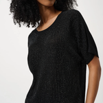 Woman wearing a black textured top against a white background