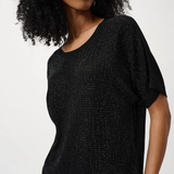 Woman wearing a black textured top against a white background